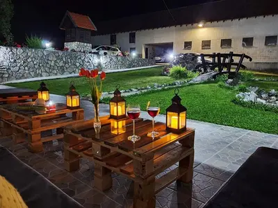 a wooden table with wine glasses and lights on it at Rtanjska bajka in Boljevac