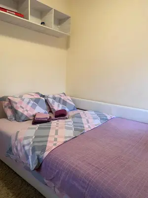 a bedroom with a bed with a purple comforter at Apartman Ana in Vrnjačka Banja