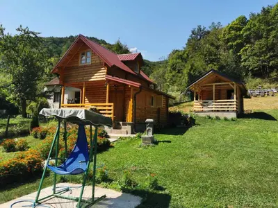 a log cabin in the yard next to a house at Vikendice Mijajlović 1 in Kuršumlija