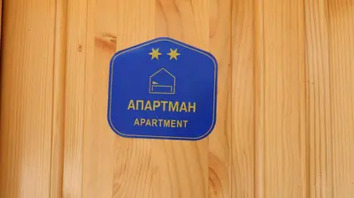 a blue sign on a wooden wall at Vikendice Mijajlović 1 in Kuršumlija