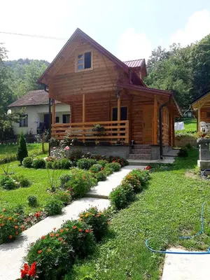 a log house with a garden in front of it at Vikendice Mijajlović 1 in Kuršumlija