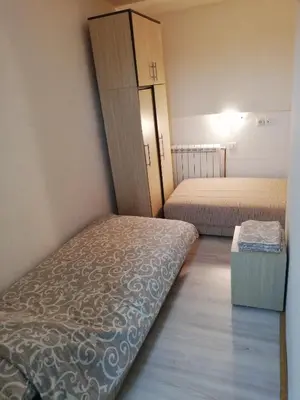 a small room with two beds and a closet at NOV-dve spavaće sobe in Kopaonik