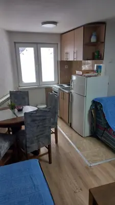 a kitchen with a table and a white refrigerator at NOV-dve spavaće sobe in Kopaonik