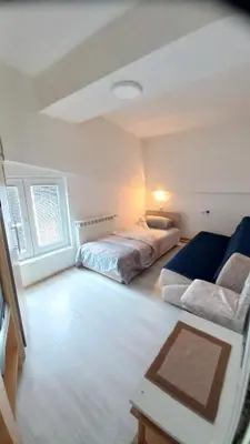 a bedroom with two beds and a couch in it at NOV-dve spavaće sobe in Kopaonik