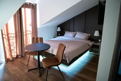 a bedroom with a bed and a table and chairs at Apartmani Jović in Kuršumlija