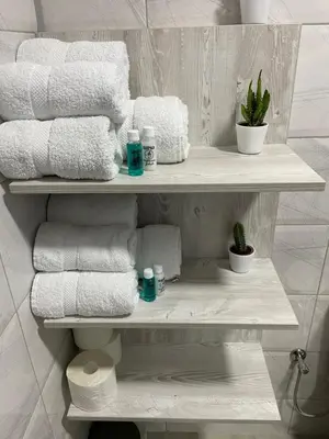 a stack of towels on a shelf in a bathroom at Apartmani Jović in Kuršumlija