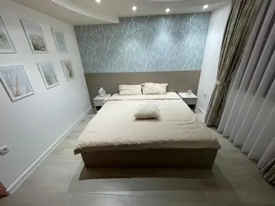 a bedroom with a large bed and two tables at Apartmani Jović in Kuršumlija