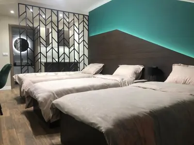 a group of three beds in a room at Apartmani Jović in Kuršumlija
