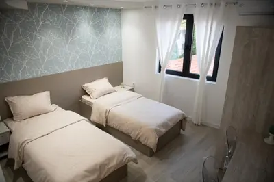 a room with two beds and a window at Apartmani Jović in Kuršumlija