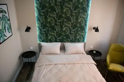 a bedroom with a bed with a green head board at Apartmani Jović in Kuršumlija