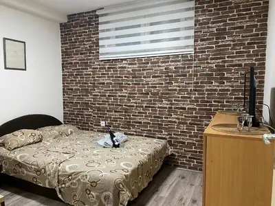 a bedroom with a bed and a brick wall at Apartman Urosevic in Jagodina