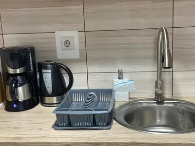 a dish drying rack next to a kitchen sink at Apartman Urosevic in Jagodina