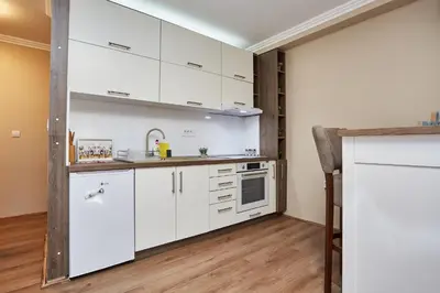 a kitchen with white cabinets and a sink at AquaLux in Soko Banja