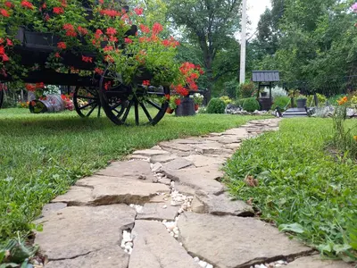 a stone path with a carriage with flowers on it at Smestaj Stanisavljevic in Soko Banja