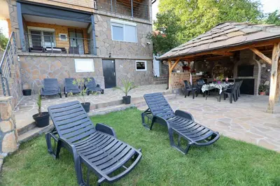 a group of chairs and a table in a yard at Vila Nemir Zavojsko jezero in Pirot
