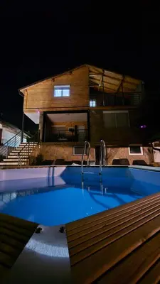 a swimming pool in front of a house at night at Vila Nemir Zavojsko jezero in Pirot