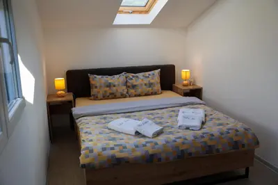a bedroom with a bed with two towels on it at Vila Nemir Zavojsko jezero in Pirot