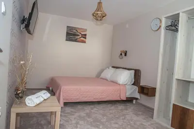 a small bedroom with a bed and a table at Mehana apartmani in Leskovac