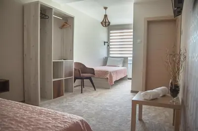 a bedroom with two beds and a desk and a chair at Mehana apartmani in Leskovac