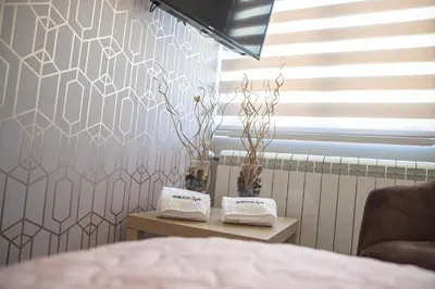 a bedroom with a bed and two tables with towels at Mehana apartmani in Leskovac
