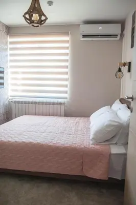 a bedroom with a bed and a window at Mehana apartmani in Leskovac