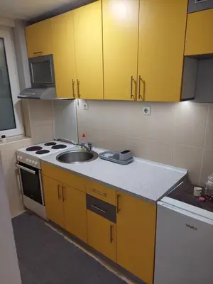 a kitchen with yellow cabinets and a sink at Vrnjacki apartmani in Vrnjačka Banja
