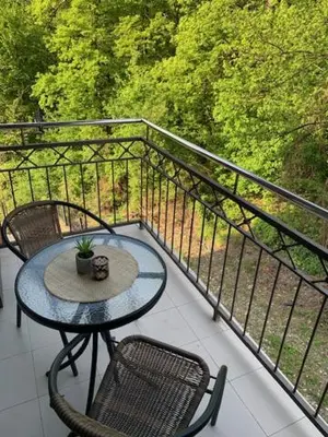 a table and two chairs on a balcony at Vrnjacki apartmani in Vrnjačka Banja