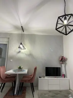 a living room with a dining table and a tv at VIP APARTMAN 2020 in Vrnjačka Banja
