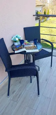 a patio table with two chairs and a table with a book at VIP APARTMAN 2020 in Vrnjačka Banja