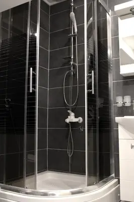 a shower with a glass door in a bathroom at Bianco nero appartamento in Niš