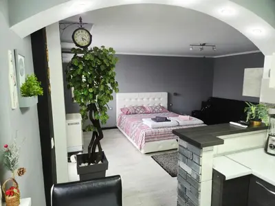 a bedroom with a bed and a desk with a clock at Savić Apartment CENTER - PARKING FREE in Niš