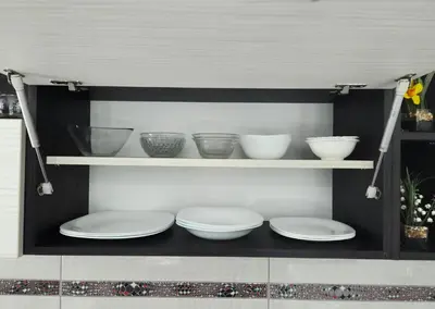 three plates and bowls on shelves in a kitchen at Savić Apartment CENTER - PARKING FREE in Niš