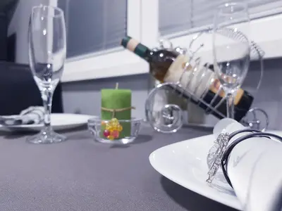 a table with wine glasses and a plate with a candle at Savić Apartment CENTER - PARKING FREE in Niš