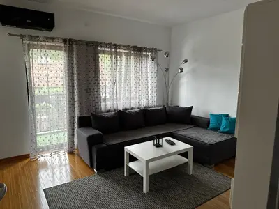 a living room with a black couch and a table at Apartman Alibi in Boljevac