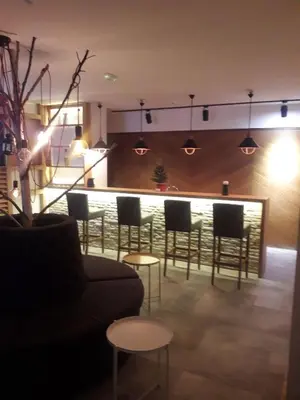 a lobby with a bar with chairs and a couch at KAMENA 6 in Kopaonik