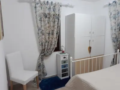a bedroom with a bed and a chair and a cabinet at Vila Tiha noc in Kopaonik