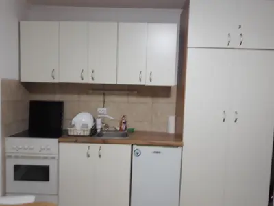 a white kitchen with white cabinets and a sink at Vila Tiha noc in Kopaonik
