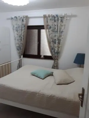 a bed with two pillows and a window at Vila Tiha noc in Kopaonik