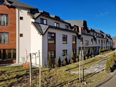 a row of houses with solar panels on the facade at Milmari Pahulja in Kopaonik