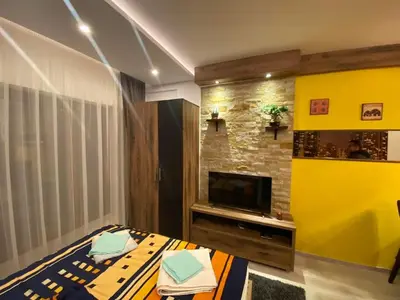 a living room with a bed and a tv at Milmari Pahulja in Kopaonik