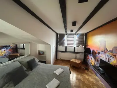 a bedroom with a large bed and a large window at MM Apartman in Kruševac