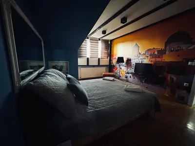 a bedroom with a bed and a large window at MM Apartman in Kruševac