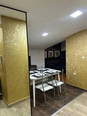a dining room with a white table and chairs at MM Apartman in Kruševac