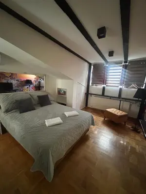 a bedroom with a large bed with two towels on it at MM Apartman in Kruševac