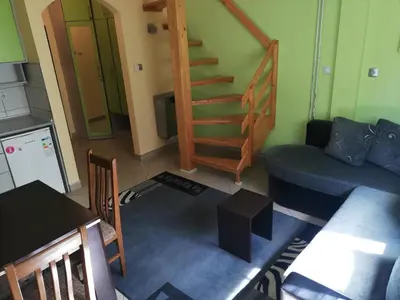 a living room with a couch and a table and a staircase at Duplex lux in Kopaonik