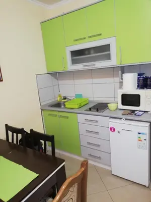 a kitchen with lime green cabinets and a table at Duplex lux in Kopaonik