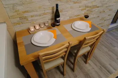 a table with two white plates and a bottle of wine at Apartman Ristić in Vrnjačka Banja