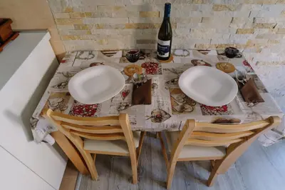 a table with two chairs and a bottle of wine at Apartman Ristić in Vrnjačka Banja