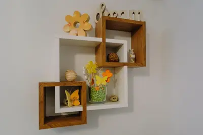 a shelf on a wall with a vase of flowers at Apartman Ristić in Vrnjačka Banja