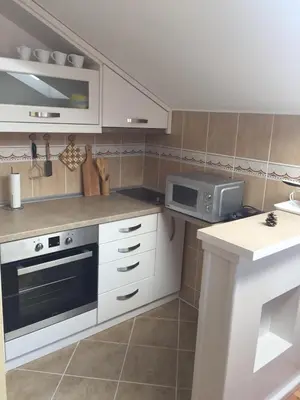 a kitchen with white cabinets and a microwave at Apartmani Grand LUX in Vrnjačka Banja